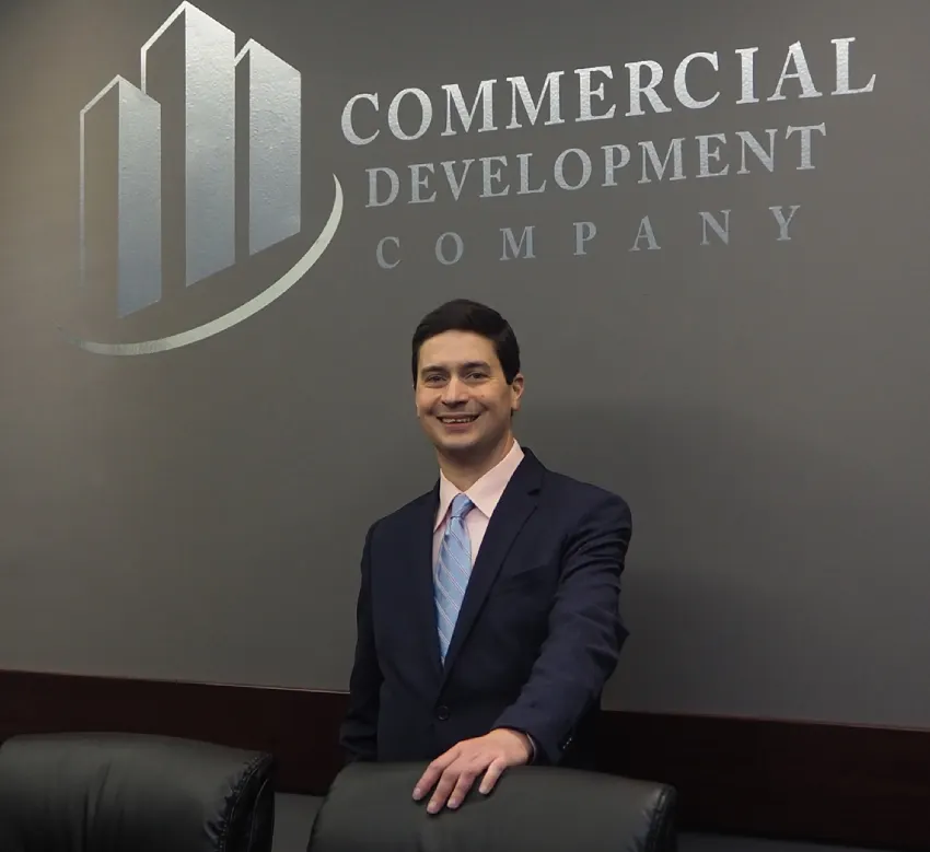 A man in suit and tie sitting at a desk.