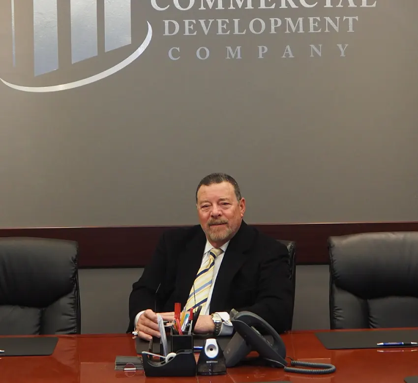 A man sitting at the head of a conference table.