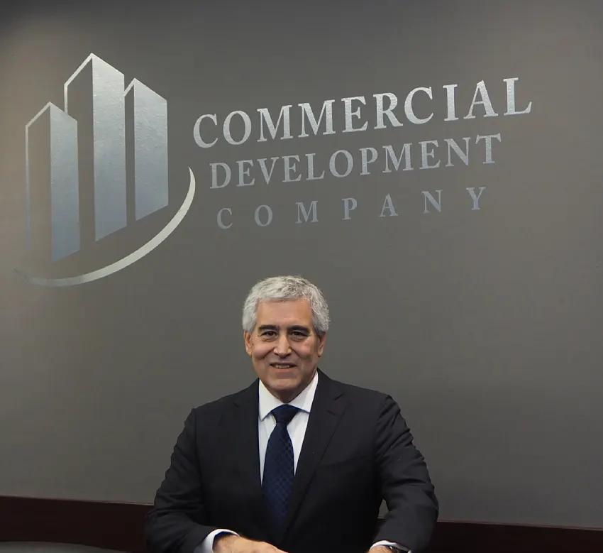 A man in suit and tie sitting at a table.