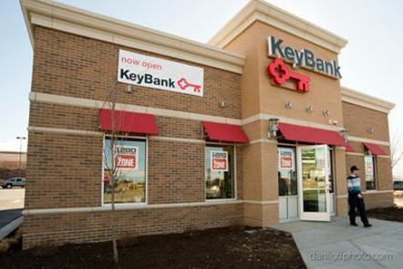 A key bank branch with red awnings and a sign.