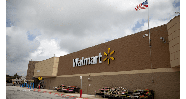 A large walmart store with trucks parked in front of it.