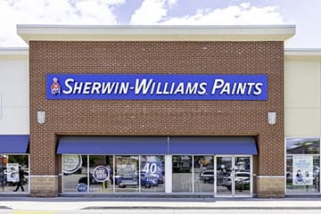 A store front of a paint shop with blue awnings.