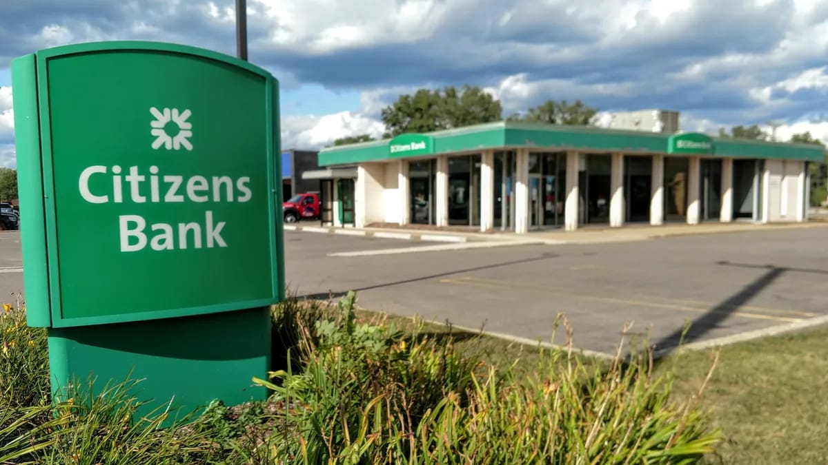 A green sign in front of a bank building.