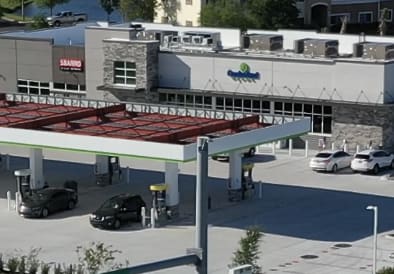 A gas station with cars parked at the pumps.